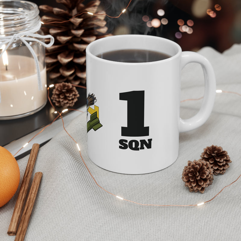 White mug with '1 Sqn' design on a table with decorative items